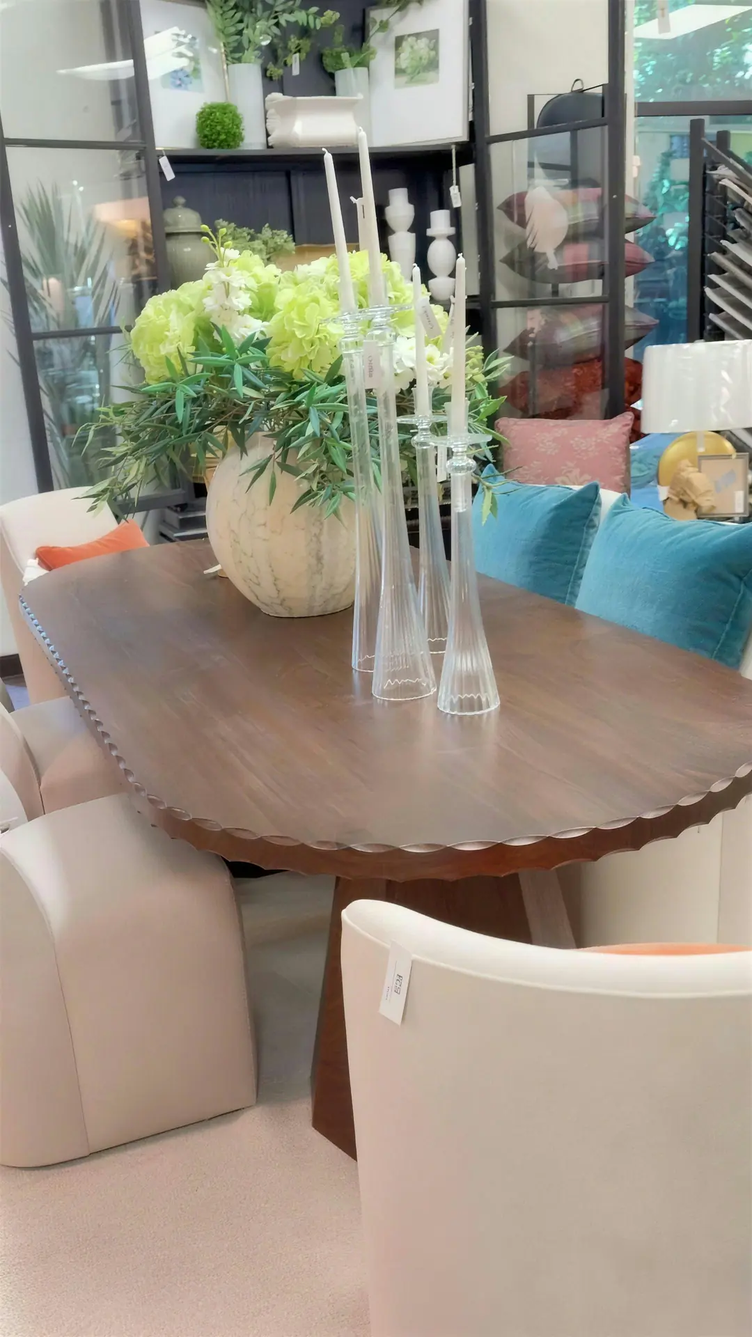Scalloped dining table set with glass candlesticks and a floral centerpiece