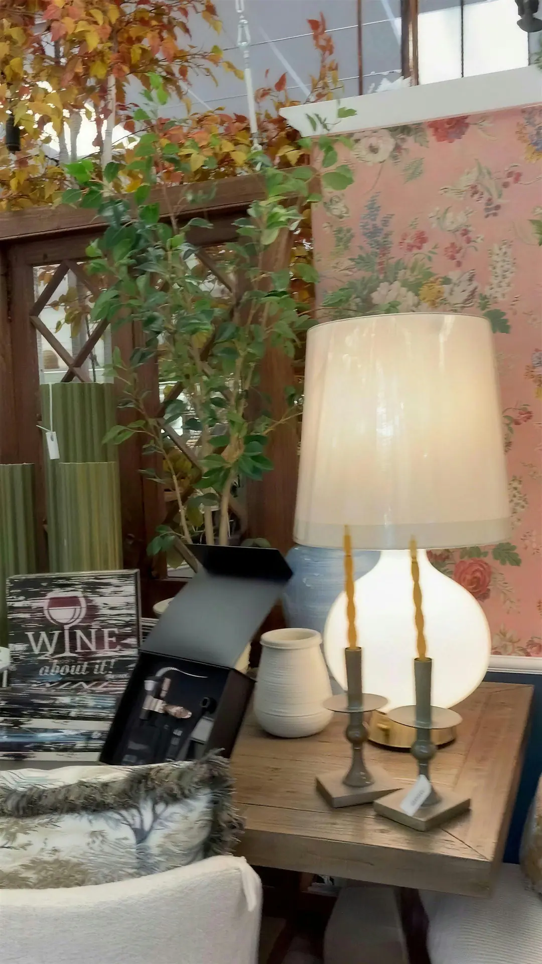 Lamp on a side table in front of floral wallpaper
