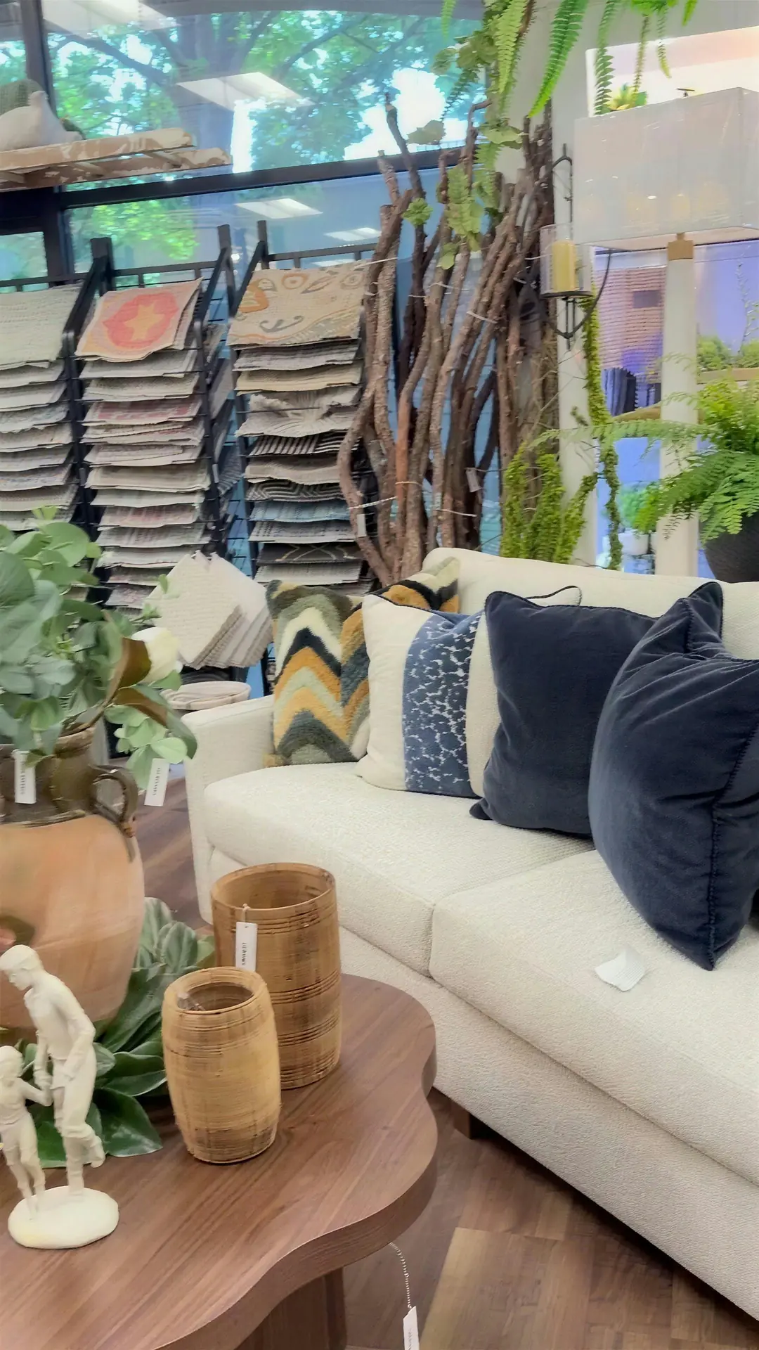 White sofa with patterned pillows in front of the rug racks