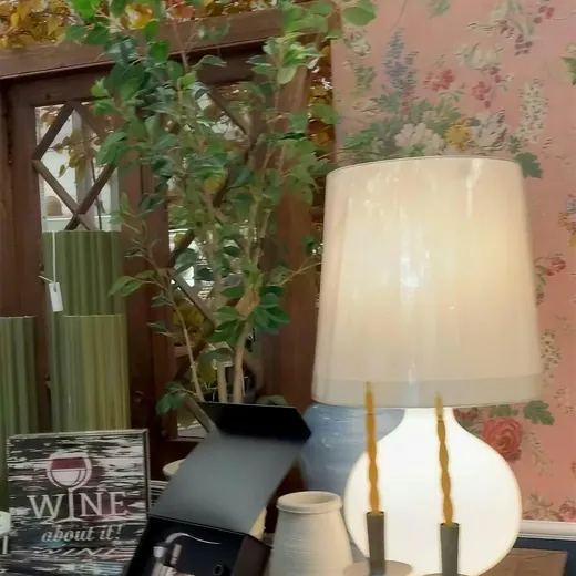 A linen lamp against floral wallpaper